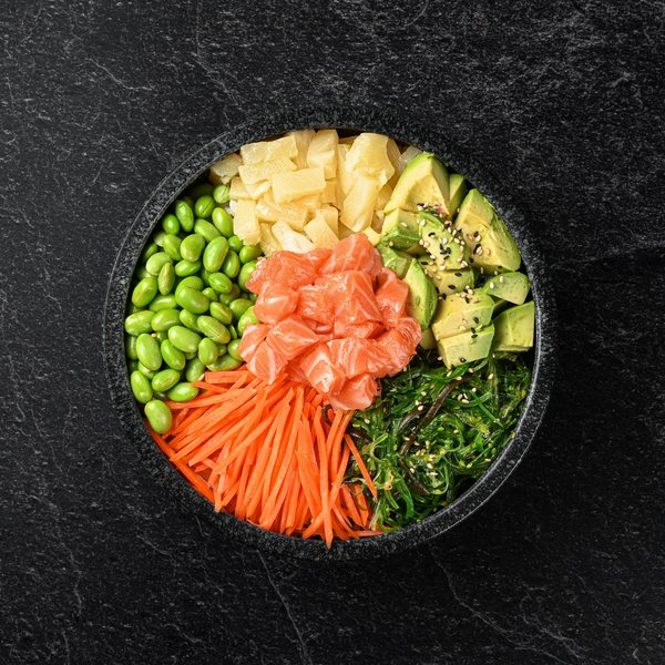 Poké bowl med laks, edamame, avocado og revet gulerod.